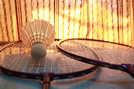shuttlecock and pair of badminton rackets thumbnail