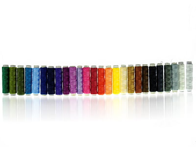 assorted-color thread spool lot on white suface thumbnail