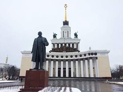 statue of man outside brown and white concrete infrastructure thumbnail