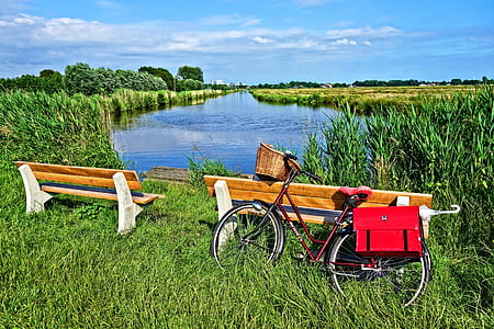 red dutch bicycle near wooden bench during daytime thumbnail