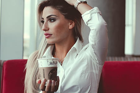 woman in white dress shirt holding a Star Bucks coffee cup thumbnail