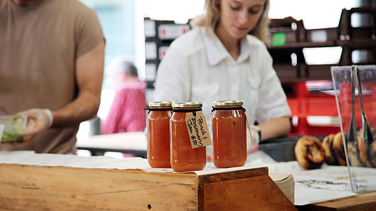woman standing near three glass mason jars in room thumbnail