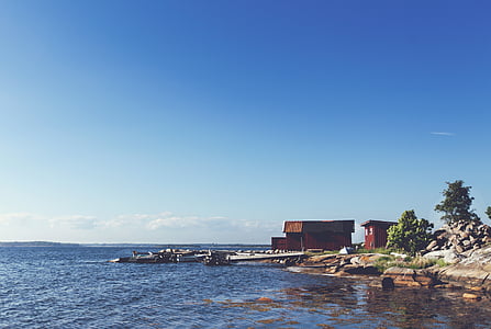 red house near body of water thumbnail