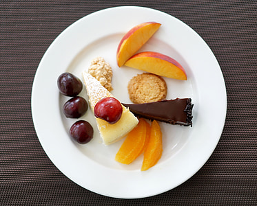 two sliced cakes with sliced fruits on round white ceramic plate thumbnail
