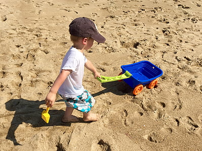 boy pulling pull wagon on the sand thumbnail