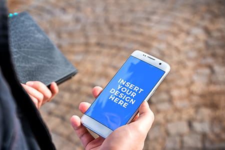 PSD Mockup of modern white smartphone in the hand of businessman on the street thumbnail