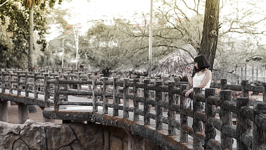 Woman in White Shirt Standing on Black Bridge thumbnail