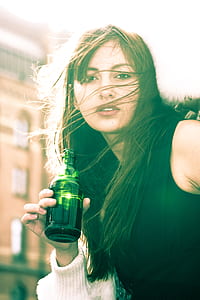 Woman In Black Sleeveless Shirt Holding A Bottle thumbnail