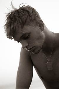 grayscale photo of topless man with dog tag pendant necklace thumbnail