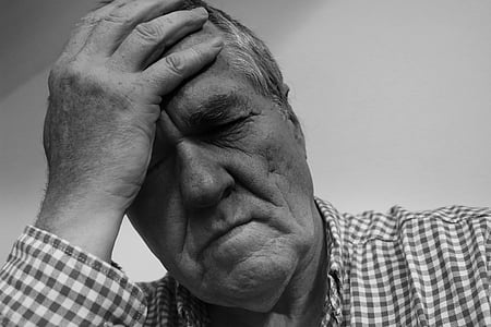 gray scale photo of man holding his head thumbnail