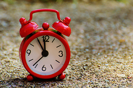 red alarm clock on brown pebbles thumbnail