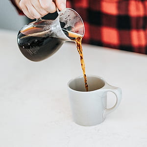 person pouring coffee in mug thumbnail