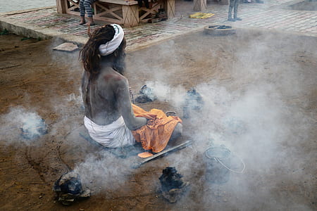 man sitting on ground surrounded with smoke thumbnail
