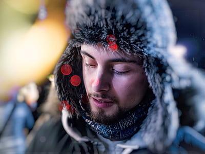 selective focus photography of man wearing black fur aviator hat thumbnail