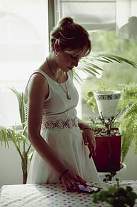 woman standing while using mobile phone thumbnail