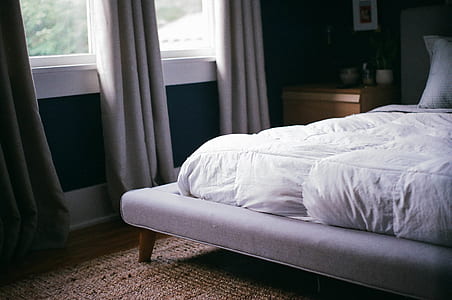 white bed near window with gray curtain thumbnail