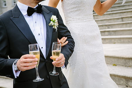man wearing suit beside bride holding two champagne flutes thumbnail