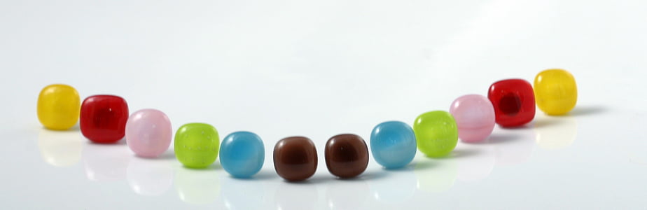 assorted-color beads on white surface thumbnail