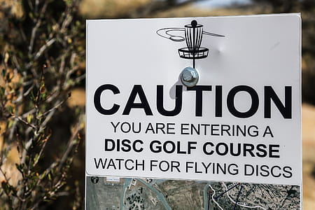 Sign warning hikers to watch out for flying frisbee golf disks. thumbnail