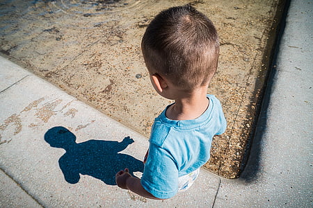 boy looking at shadow on sidewalk thumbnail