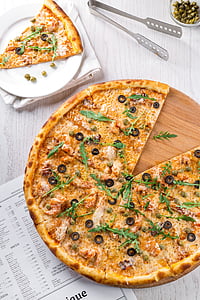 pizza with black olives on brown tray thumbnail