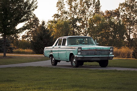 vintage green sedan on pathway beside trees during daytime thumbnail