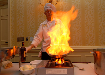 man cooking on portable stove while holding gray frypan thumbnail
