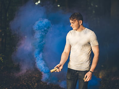 man holding blue smoke grenade thumbnail