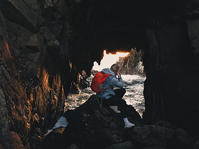 man sitting on gray rock formation thumbnail