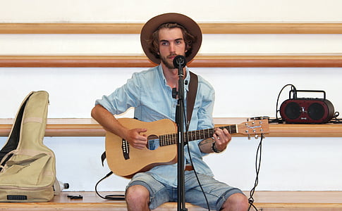 man playing brown guitar thumbnail