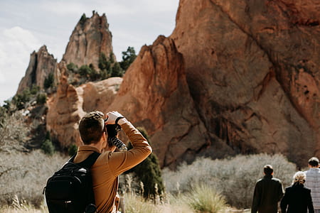 man in brown dress shirt using DSLR camera thumbnail