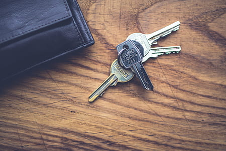 silver keys on brown wooden surface thumbnail