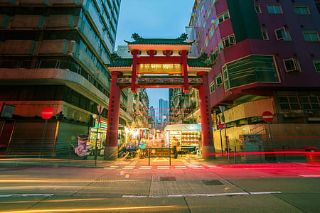 time-lapse photography of torii gate between buildings at night thumbnail