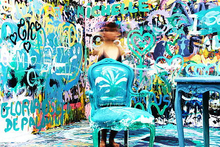 toddler standing in front of blue wooden armchair behind graffiti wall thumbnail