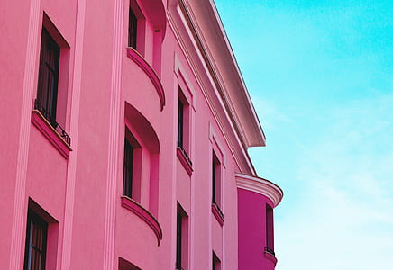 pink concrete building with window closed under blue sky thumbnail