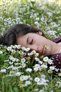 woman wearing maroon shirt lying on white petaled flowers thumbnail