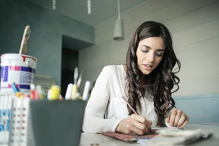 Woman Sitting While Holding Pen thumbnail