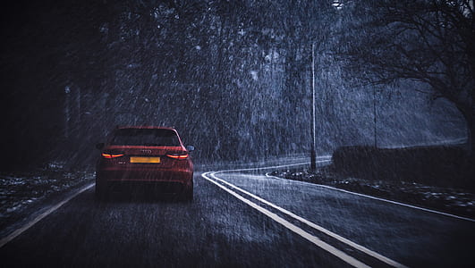 red car travelling on road while raining thumbnail