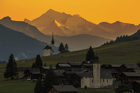 white concrete tower in front of mountain ranges thumbnail