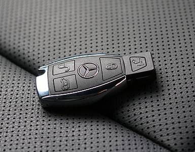 black and gray Mercedes-Benz vehicle fob on gray textile thumbnail