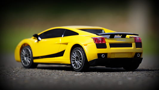selective focus photography of yellow Lamborghini Gallardo coupe die-cast metal scale model on gray surface thumbnail