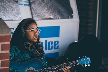 woman in blue sweater playing blue acoustic guitar thumbnail