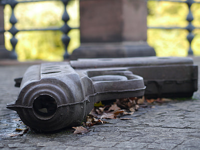 selective focus photo of black pistol on gray concrete thumbnail
