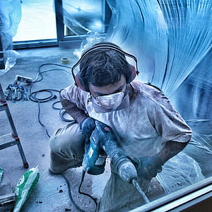 man in white crew-neck shirt holding black hammer drill thumbnail