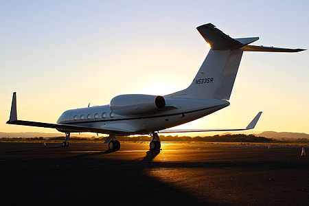 A light airplane sits on the airport runway at sunset thumbnail
