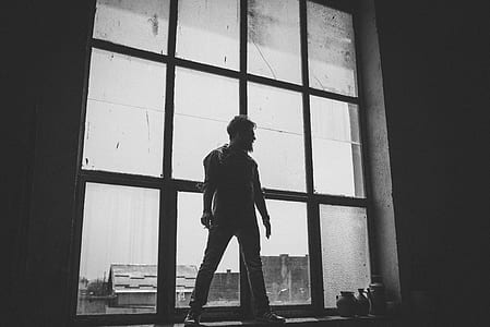 silhouette of man standing in front of glass window thumbnail