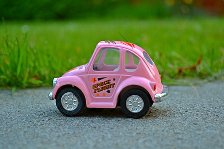 close-up photography of pink car toy near green grass field thumbnail