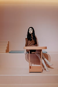 woman wearing brown cold-shoulder dress sitting beside table thumbnail