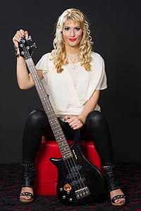 woman holding black 4-stringed electric bass guitar thumbnail