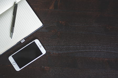 Silver Iphone 6 Beside White Book With Pen thumbnail